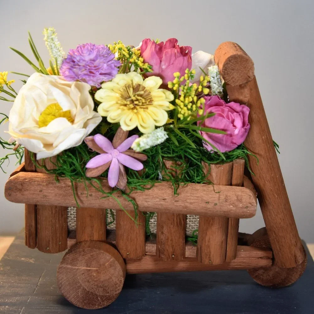 Cheerful garden arrangement of airbrushed Sola wood flowers in a garden cart